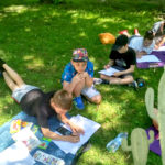 Dzieci podczas lekcji rysunku w parku