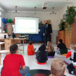 zdjęcie dzieci siedzące na poduszkach podczas prezentacji dotyczącej bezpieczeńswat w internecie