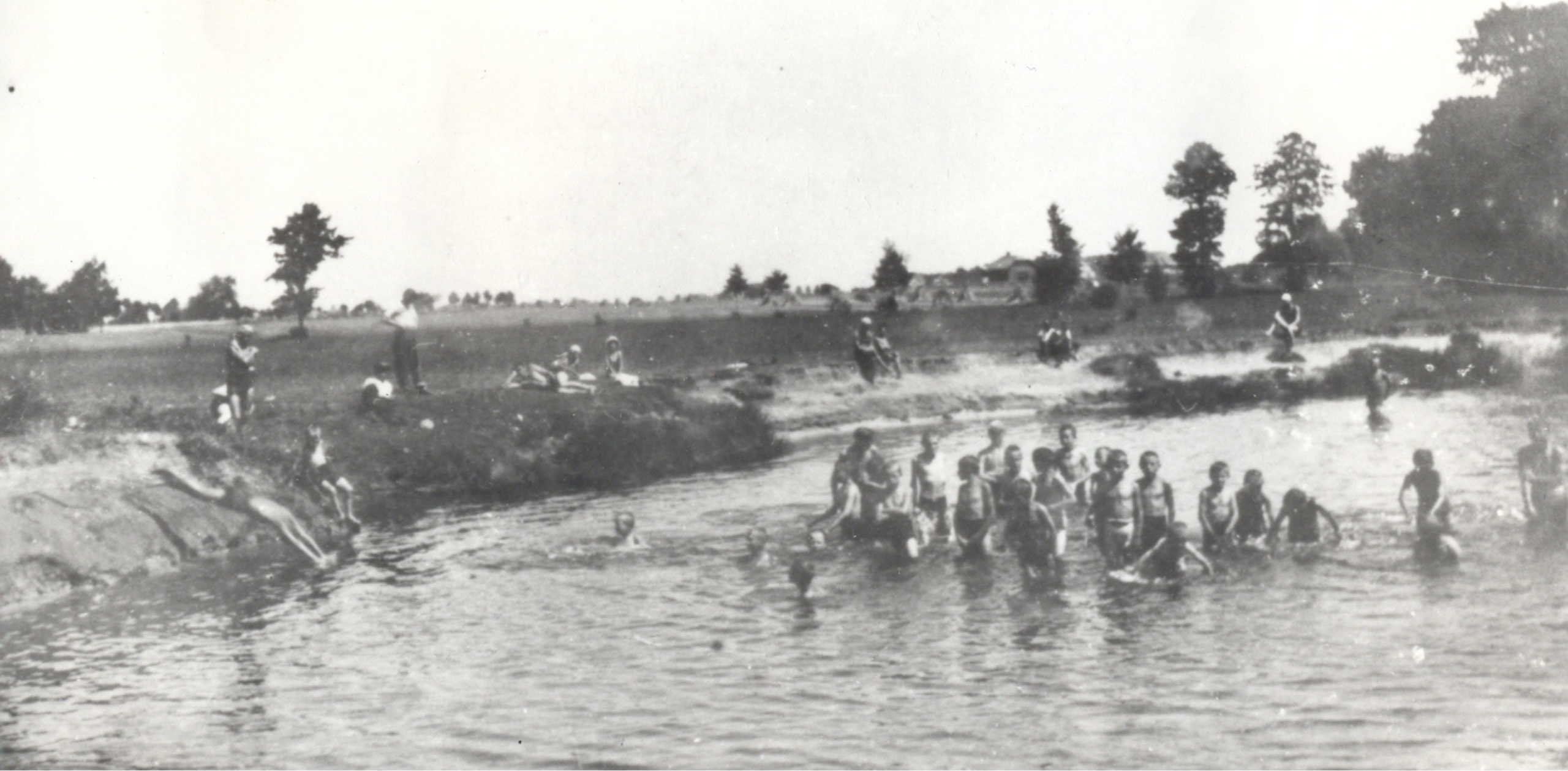 zdjęcie czarno-białe przedstawiające grupę dzieci bawiących się w wodzie