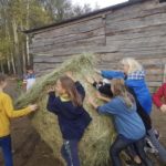 zdjęcie dzieci pchające stóg siana