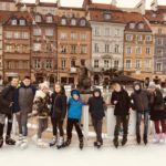 Dzieci na łyżwach na tle Starego Miasta