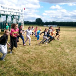 Zdjęcie grupowe, dzieci biegnące na terenie wyścigów konnych