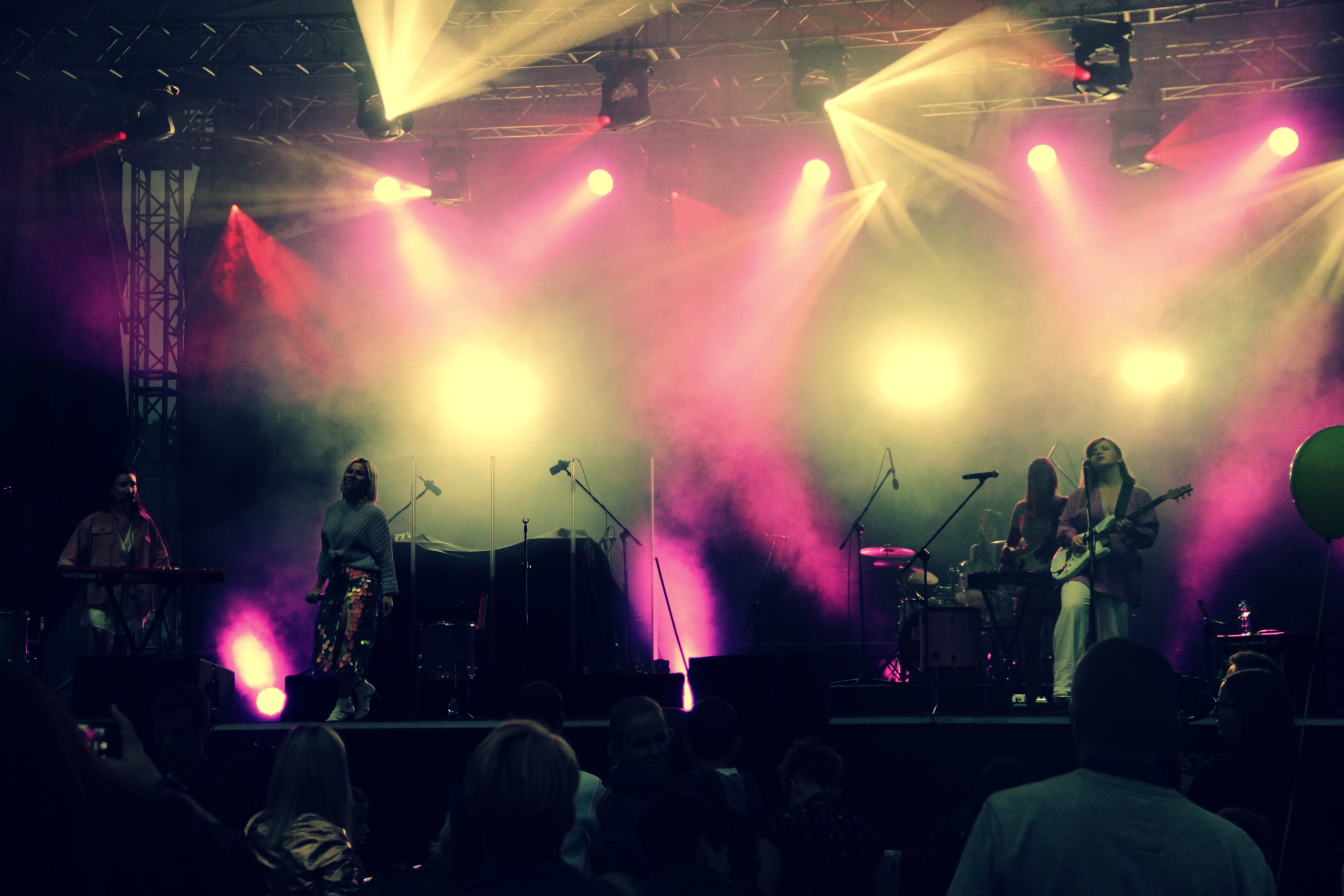 Wieczorny występ zespołu Prink Girls - wykonawcy na podświetlonej scenie