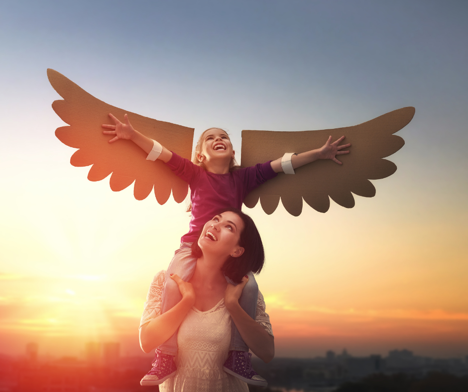 matka niosąca dziecko na barana, dziecko ma papierowe skrzydła