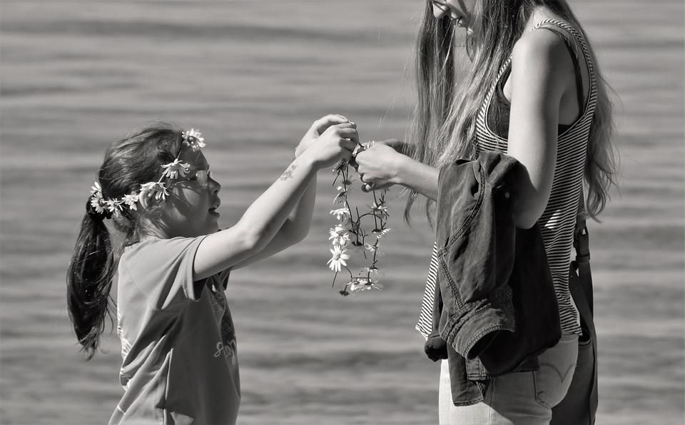 matka dająca wianek z kwiatów dziewczynce