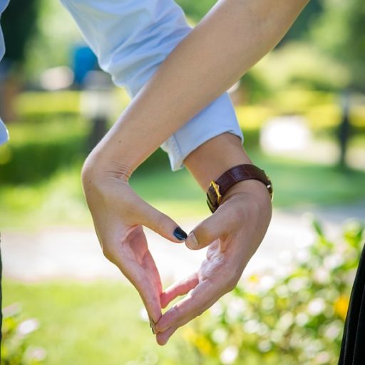 para układająca dłonie w kształt serca