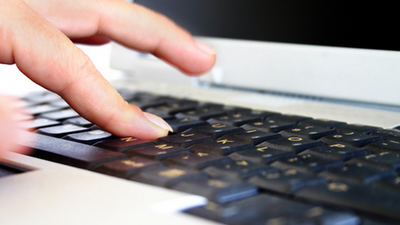 palce na klawiaturze laptopa