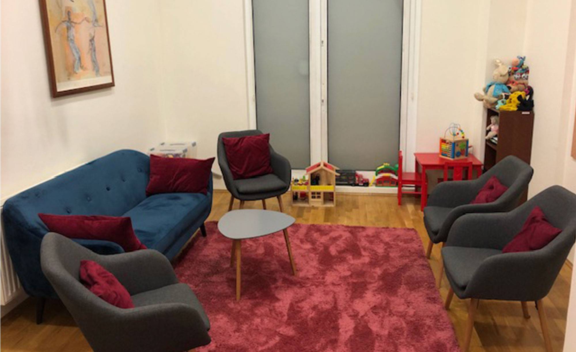 Wnętrze pokoju z kanapą, krzesłami i stolikiem.