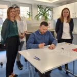 Dyrektor Jarosław Adamczuk podpisuje akty ślubowania. Towarzyszą mu trzy pracownice.